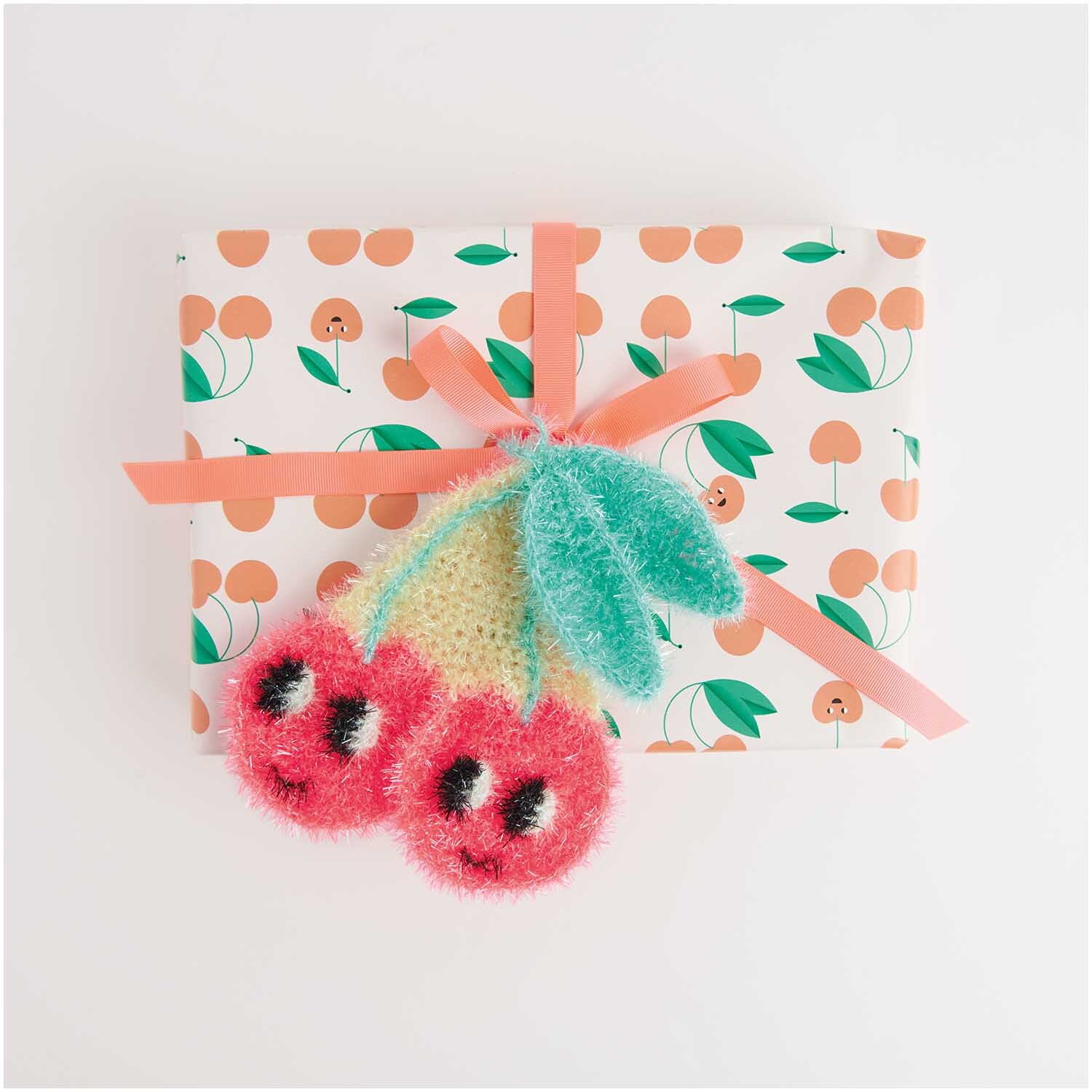 Creative Bubble von Rico Design in Aqua, 50g 90m, dekoriert ein Geschenk mit Kirschmusterpapier und Schleife.