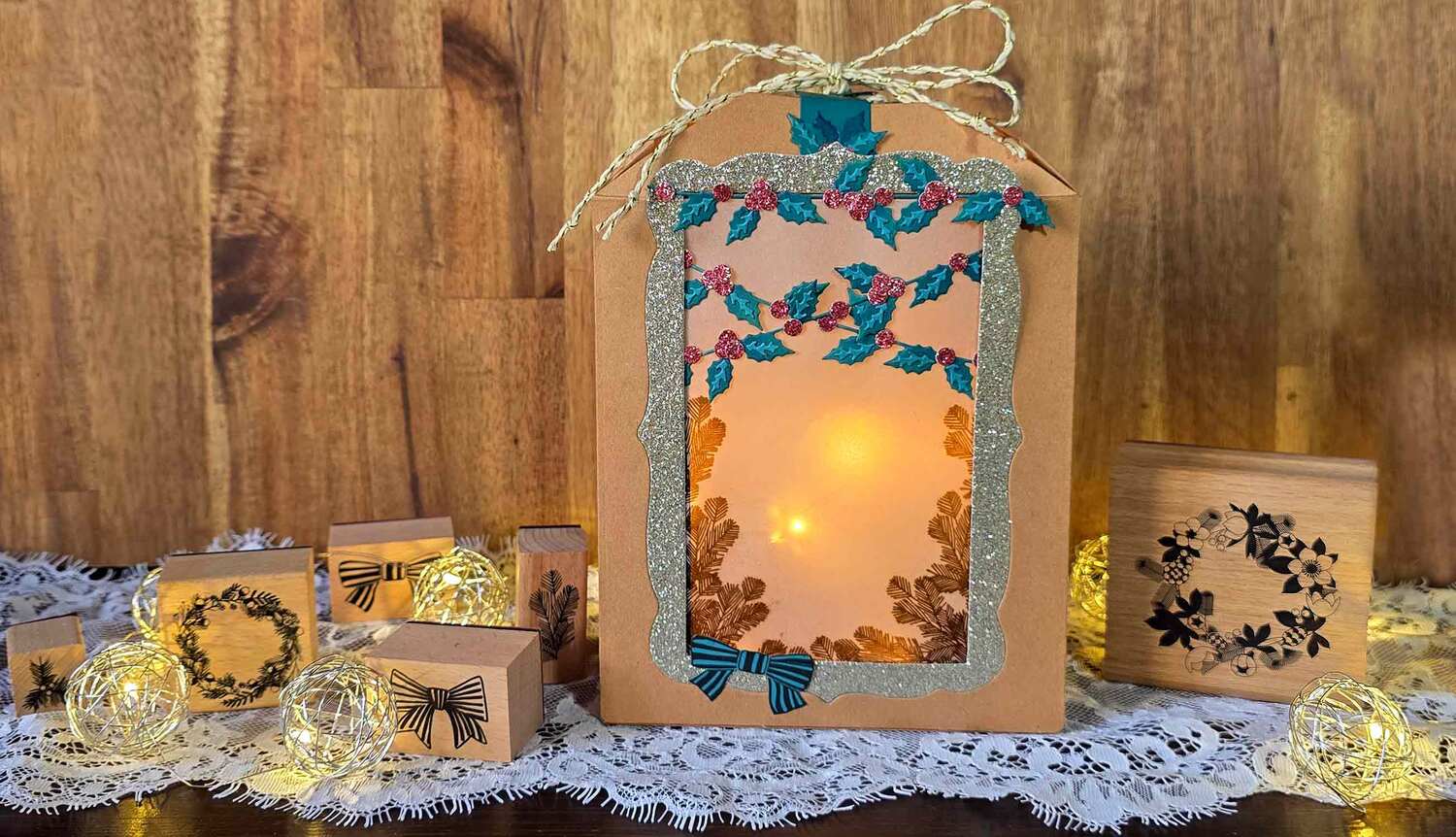 Inspiration Weihnachtslaterne basteln mit Sizzix @ankes.art: Handgemachte Laterne aus Karton mit blauen und goldenen Verzierungen, umgeben von Lichterketten.