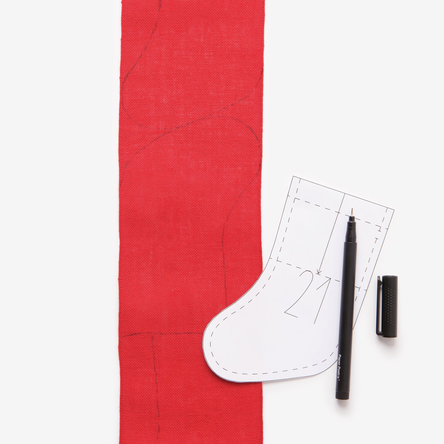Stickbuch Put a Bow on It Nr. 185 zeigt eine rote Stoffbahn mit Schablone und Stift für Adventskalender.