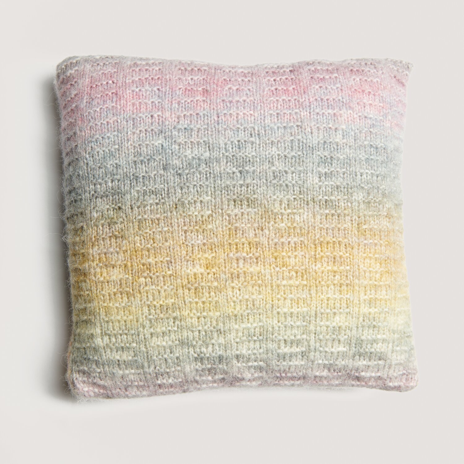 Strickset Kissen Modell 12 zeigt ein gestricktes Kissen in sanften Pastelltönen, ideal für gemütliche Wohnräume.