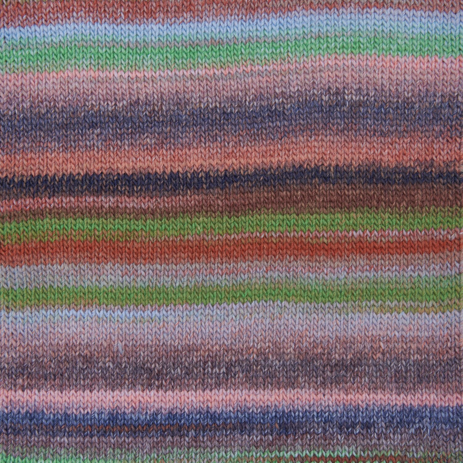 Ein gestricktes Stück aus einem Farbverlaufsgarn mit gedeckten Farben. Detailansicht eines Produktes.