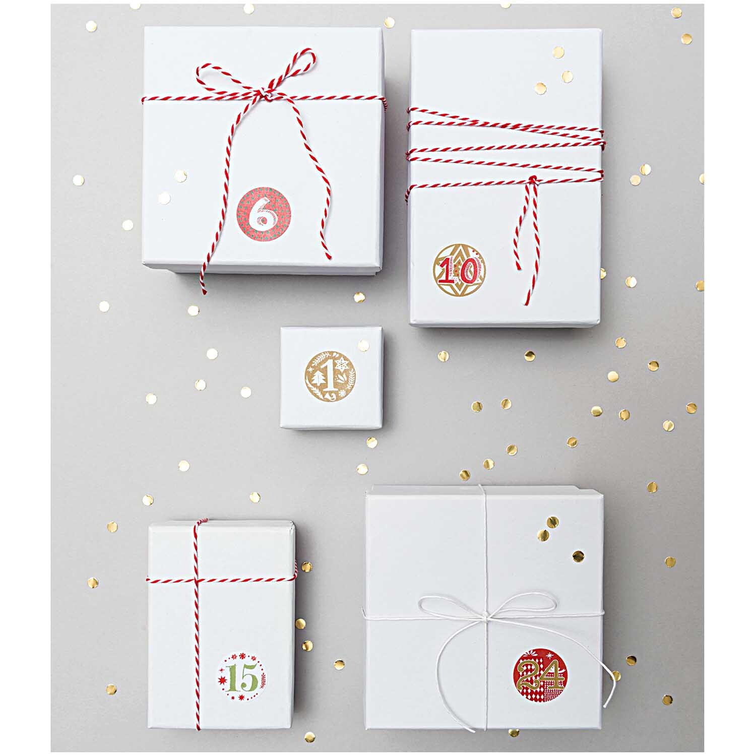 Paper Poetry Baumwollgarn umwickelt weiße Geschenke mit roten Akzenten, dekoriert von Rico Design.