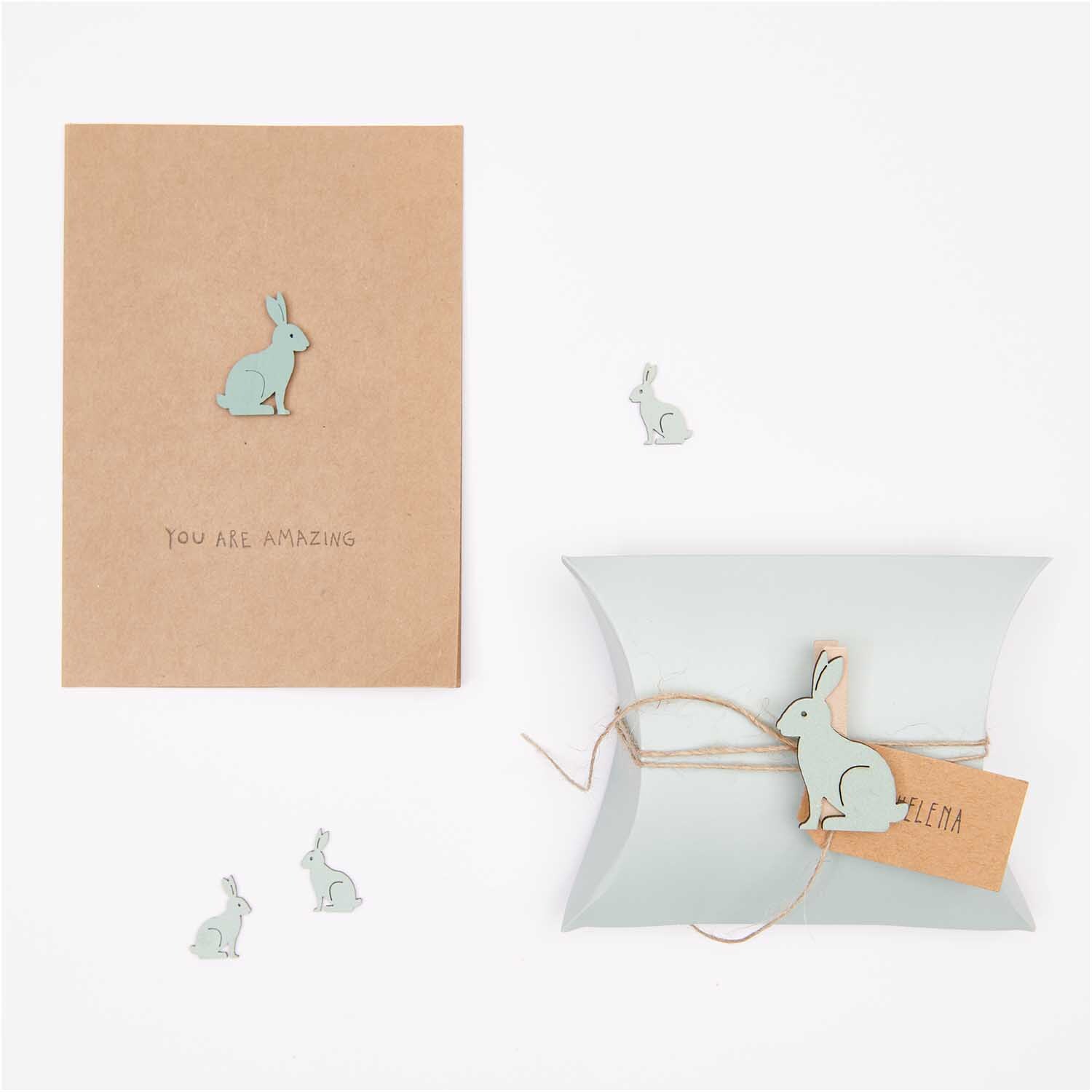 Dekoklammern Hase 6 Stück von Rico Design in Mint auf einer Karte und Geschenkbox arrangiert.
