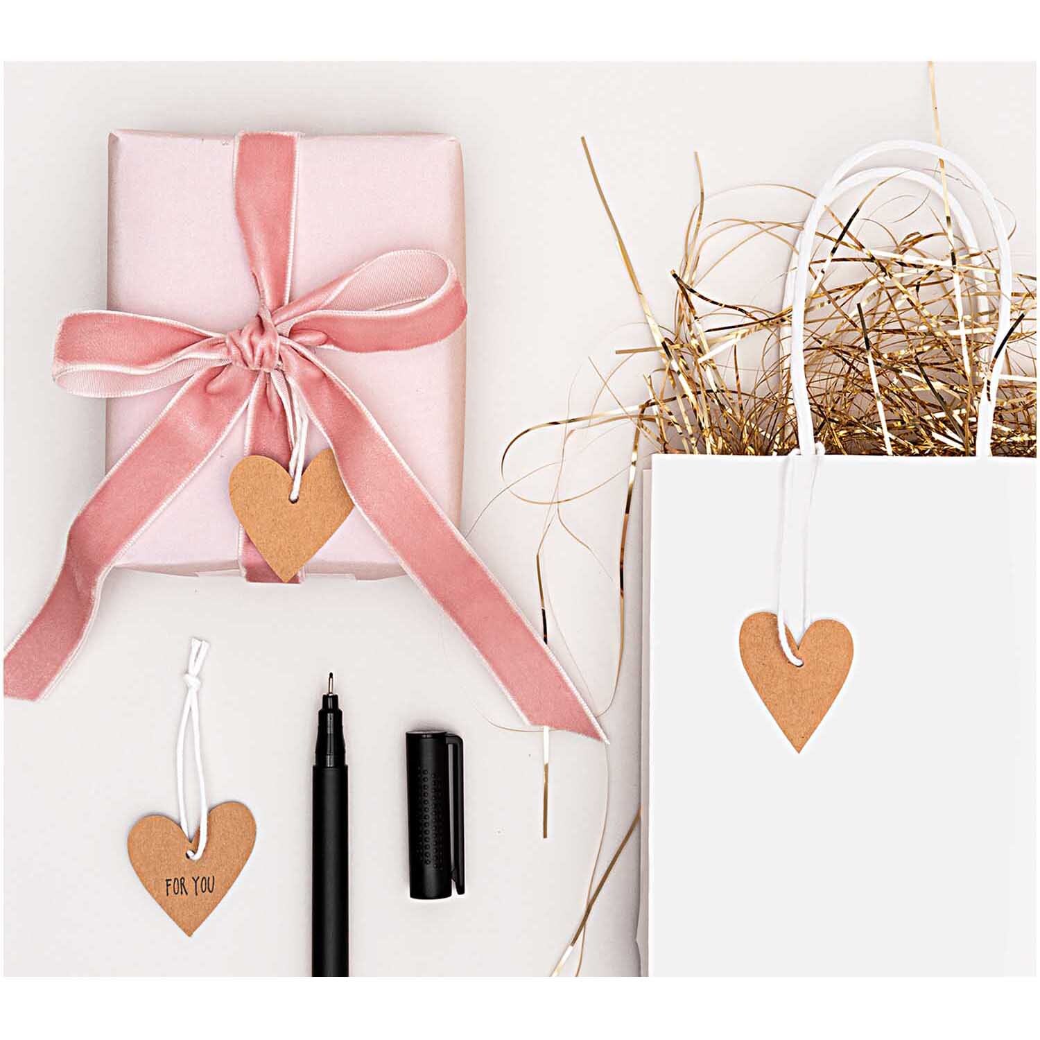 Paper Poetry Papieranhänger Herzen aus Kraftpapier in Braun, dekorativ an Geschenk und Tüte.