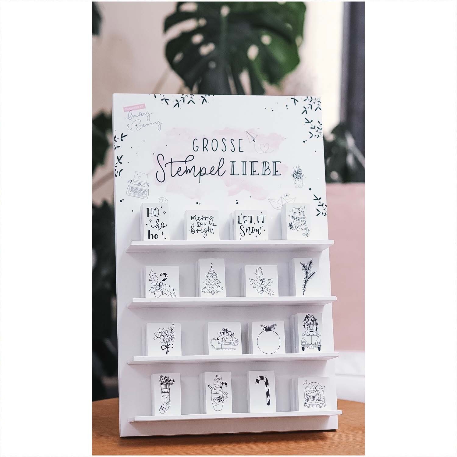 Stempel Schneekugel weiß 45x45mm, präsentiert in einem Regal mit weiteren weißen Weihnachtsstempeln von May&Berry.