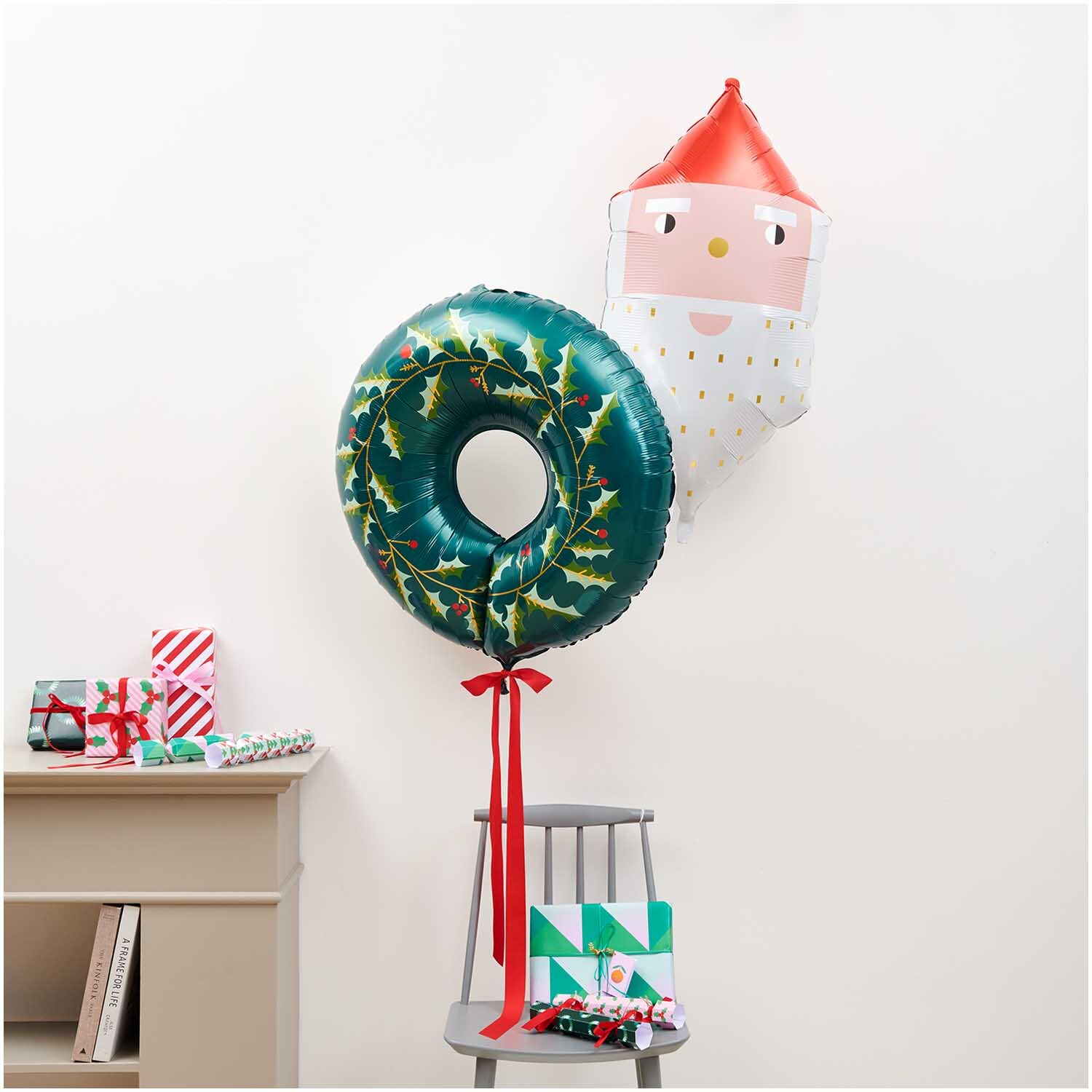 Folienballon Weihnachtsmann 41x82x33cm: Zwei bunte Ballons, einer in Weihnachtsmannform, schmücken einen Raum.