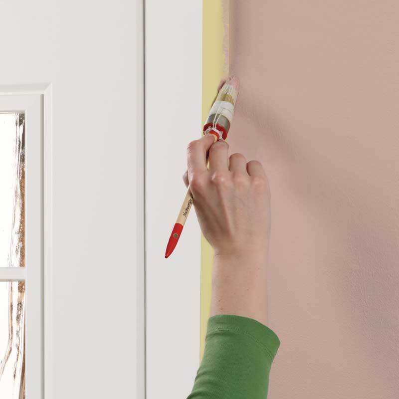 Maler-Krepp Classic 30mm 50m wird beim Streichen einer Wand neben einer Tür verwendet.