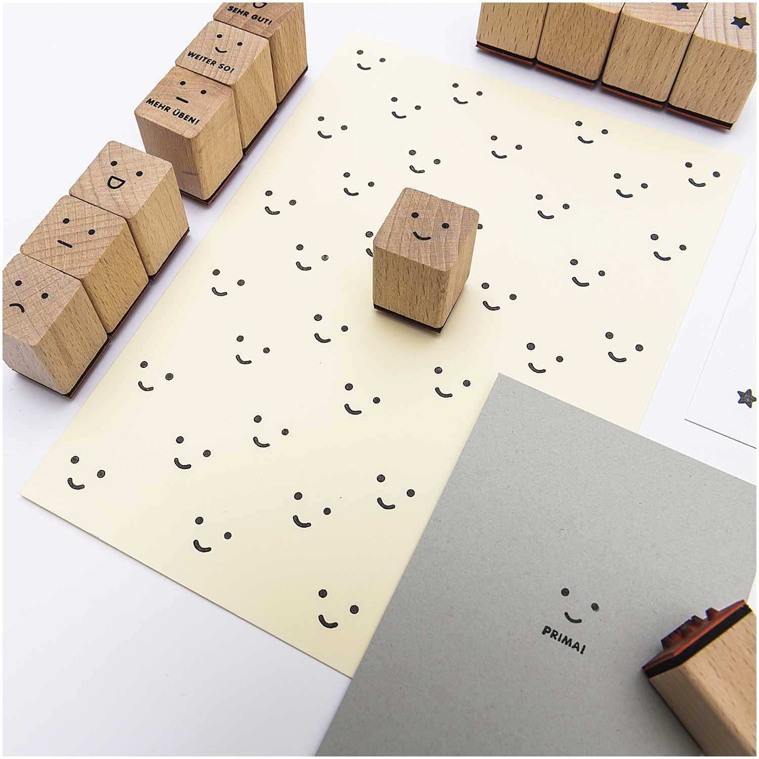 Paper Poetry Stempelset Lehrer, 13-teilig, zeigt Holzstempel mit fröhlichen Gesichtern auf Papier. Ideal für kreative Lehrerprojekte.