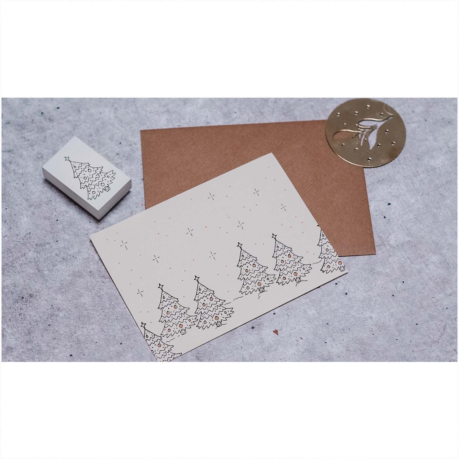 Stempel Tannenbaum weiß 35x55mm von May&Berry auf grauem Hintergrund mit braunem Umschlag und geprägtem Siegel.