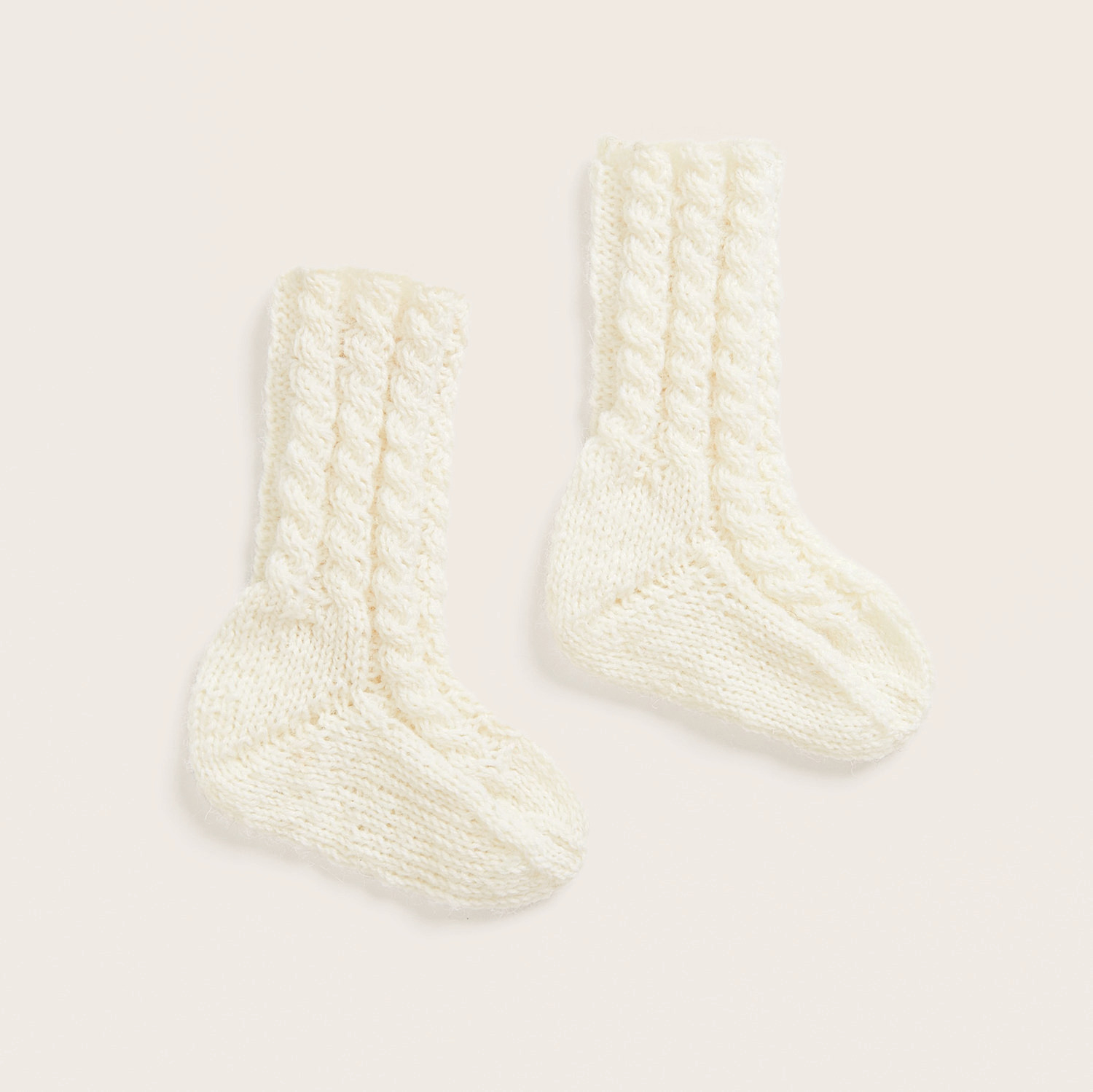 Strickset Baby- und Kindersocken Modell 02: Cremefarbene Socken mit Zopfmuster, 100g 380m, von Rico Design.