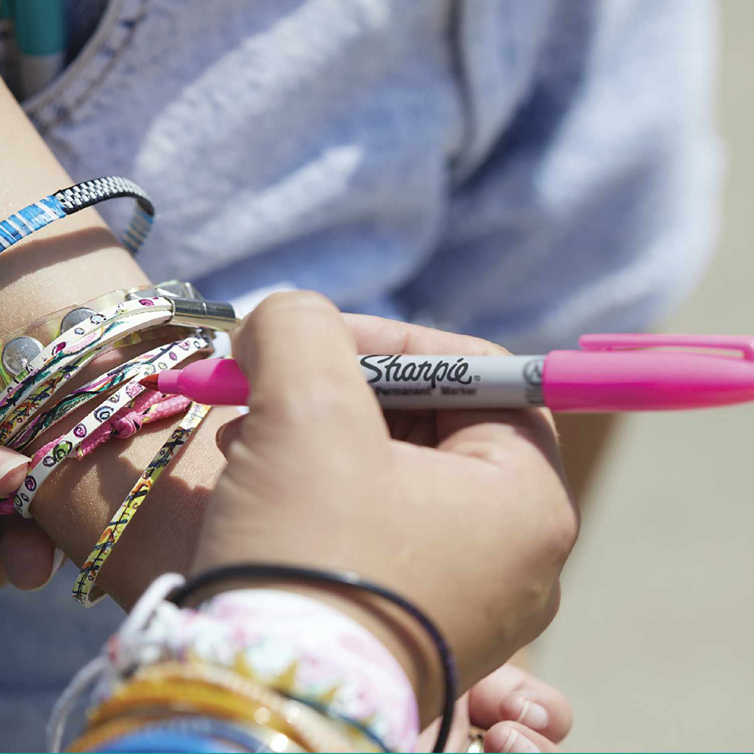 Permanentmarker 0,9mm in Aktion, pink, von Sharpie, wird auf einem Armband verwendet.