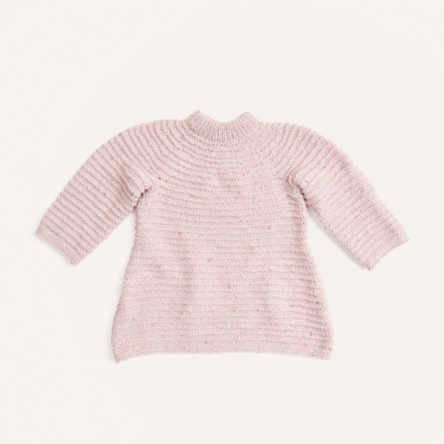 Strickset Kleid Modell 04 aus Rico Baby 040: Ein zartrosa gestricktes Baby-Kleid mit langen Ärmeln auf hellem Hintergrund.