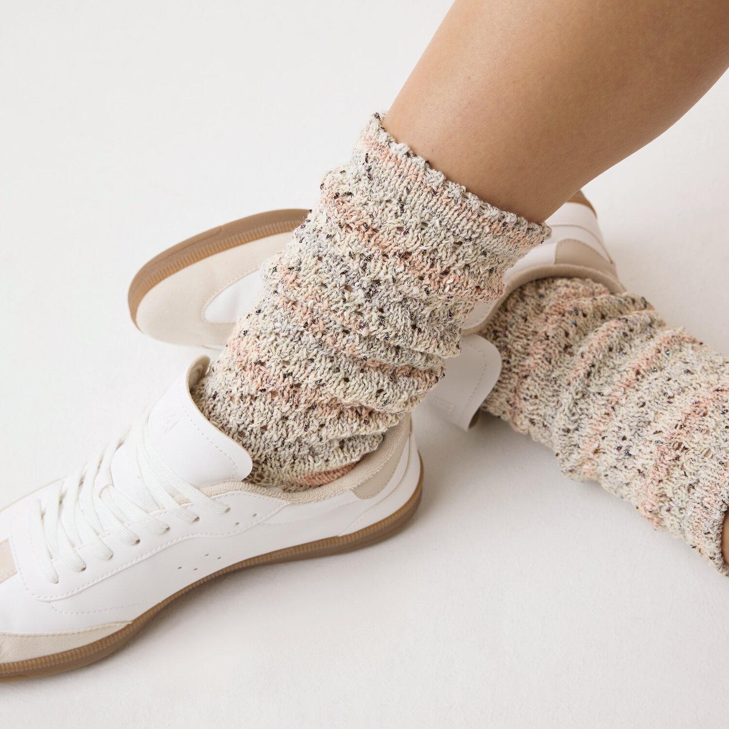 Strickset Socken Modell 14b: Beigefarbene, gestrickte Socken in Sneakers, präsentiert auf Beinen.