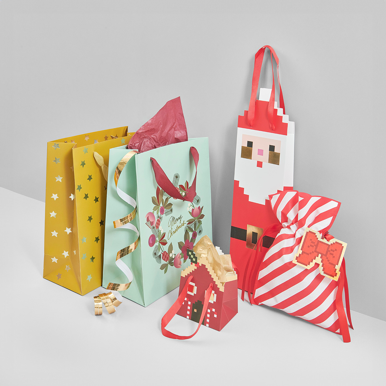 Geschenktüten in mehreren weihnachtlichen Formen und Motiven. Fotosetting graue Ecke. 