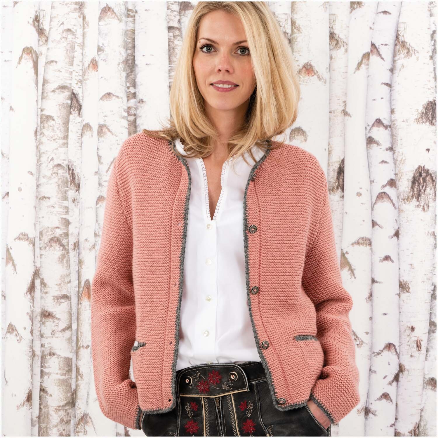 Essentials Merino Plus Tweed dk: Frau in gestrickter Jacke vor Birkenwald. Ideal für stilvolle Herbstmode.