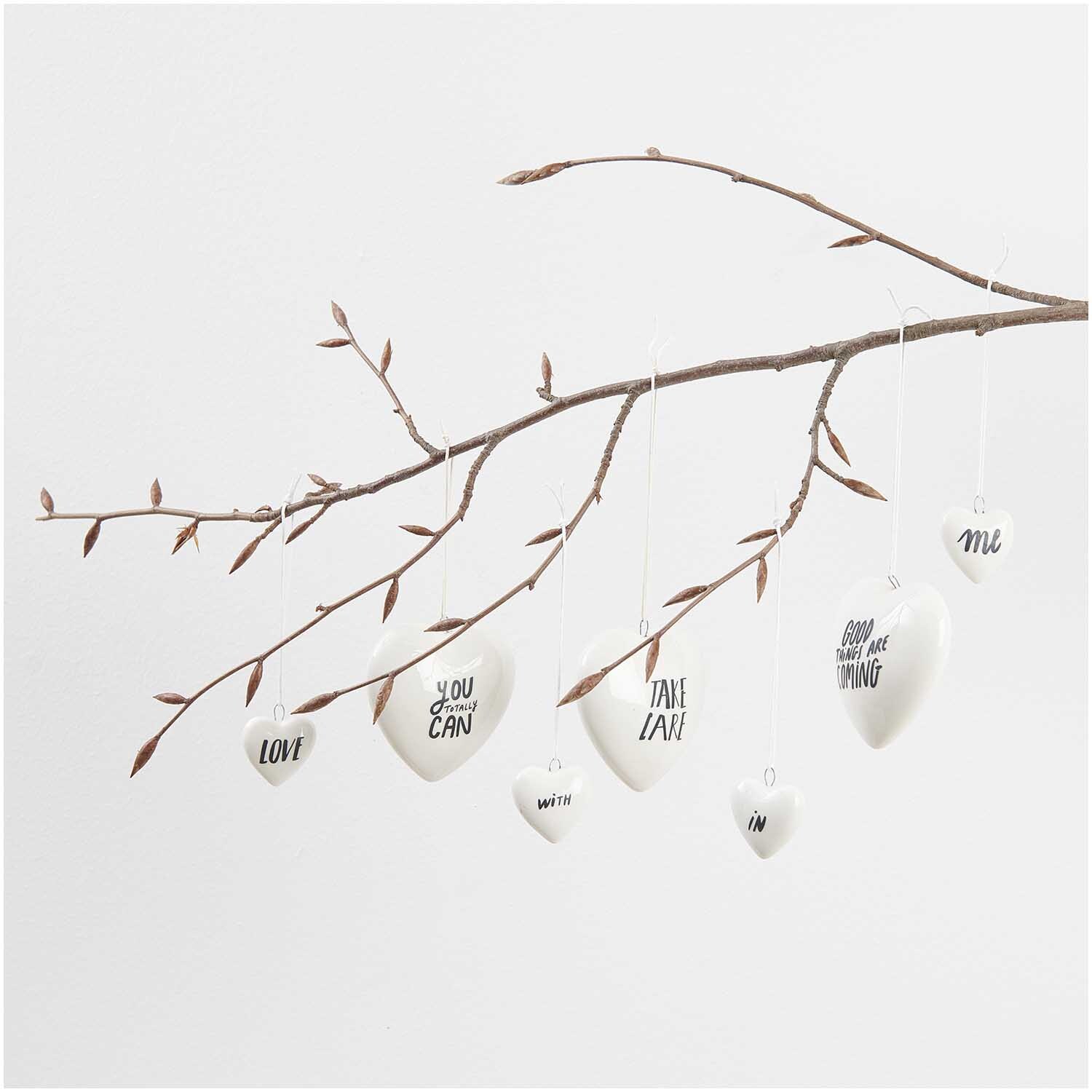 Transfermotiv Good Things are Coming: Weiße Herzanhänger mit motivierenden Sprüchen an einem Ast, 8 Stück von Rico Design.