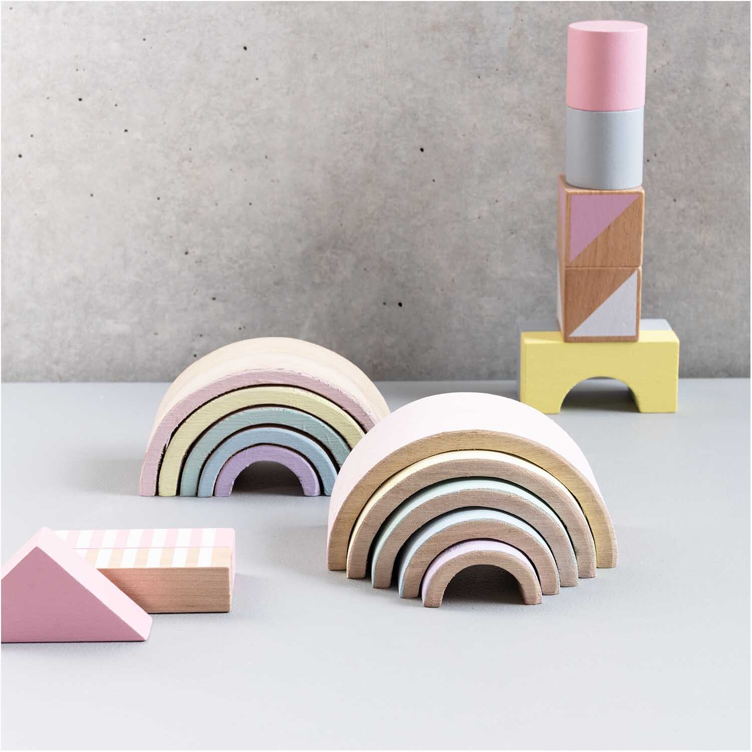 Holz-Regenbogen 12x6x5cm 5teilig in Pastellfarben, dekorativ auf grauem Hintergrund arrangiert.