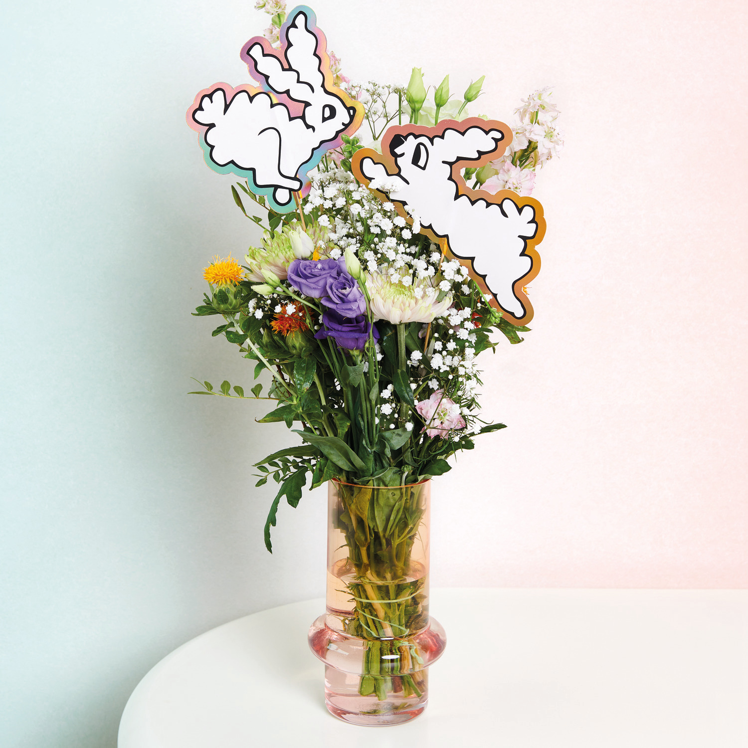 Picker Hasen XL: Zwei weiße Hasen-Dekorationen in einem Blumenstrauß mit bunten Blüten in einer Vase.