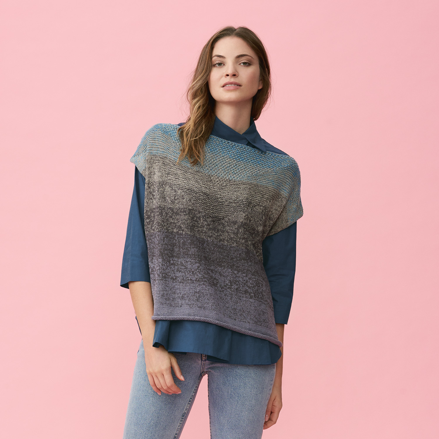 Strickanleitung Top aus Creative Cotton Dégradé Super 6: Frau trägt blau-graues Stricktop vor rosa Hintergrund.