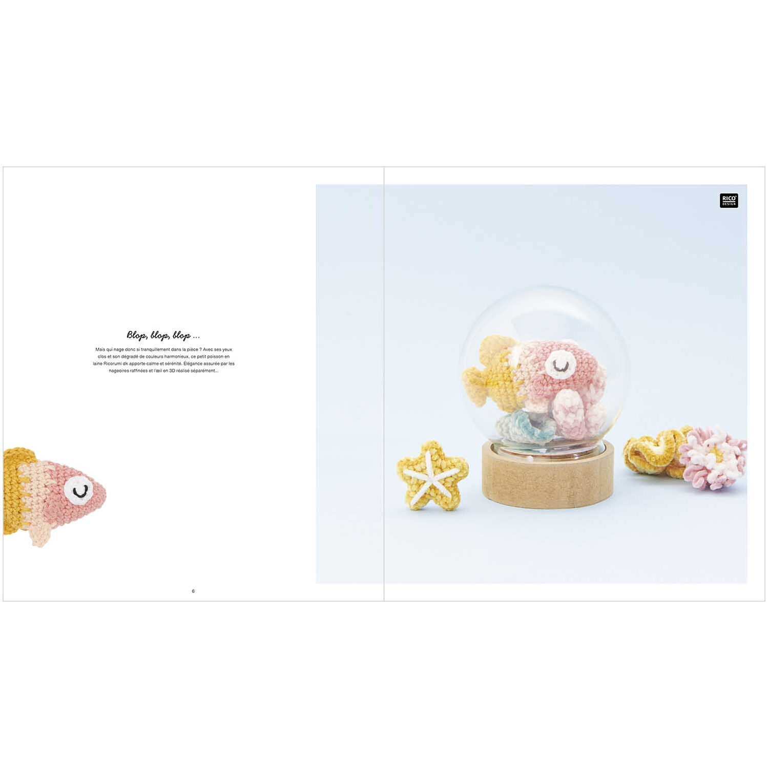 Ricorumi Underwater World: Ein gehäkelter Fisch in Rosa und Gelb von Rico Design, präsentiert in einer Glaskugel mit Seestern und Koralle.
