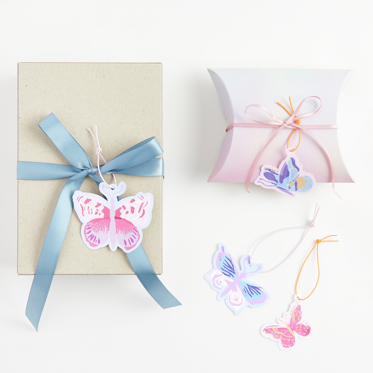 Paper Poetry Geschenkanhänger La Vie en Rose Schmetterlinge, 8 Stück, dekorativ an Geschenkboxen mit bunten Bändern befestigt.