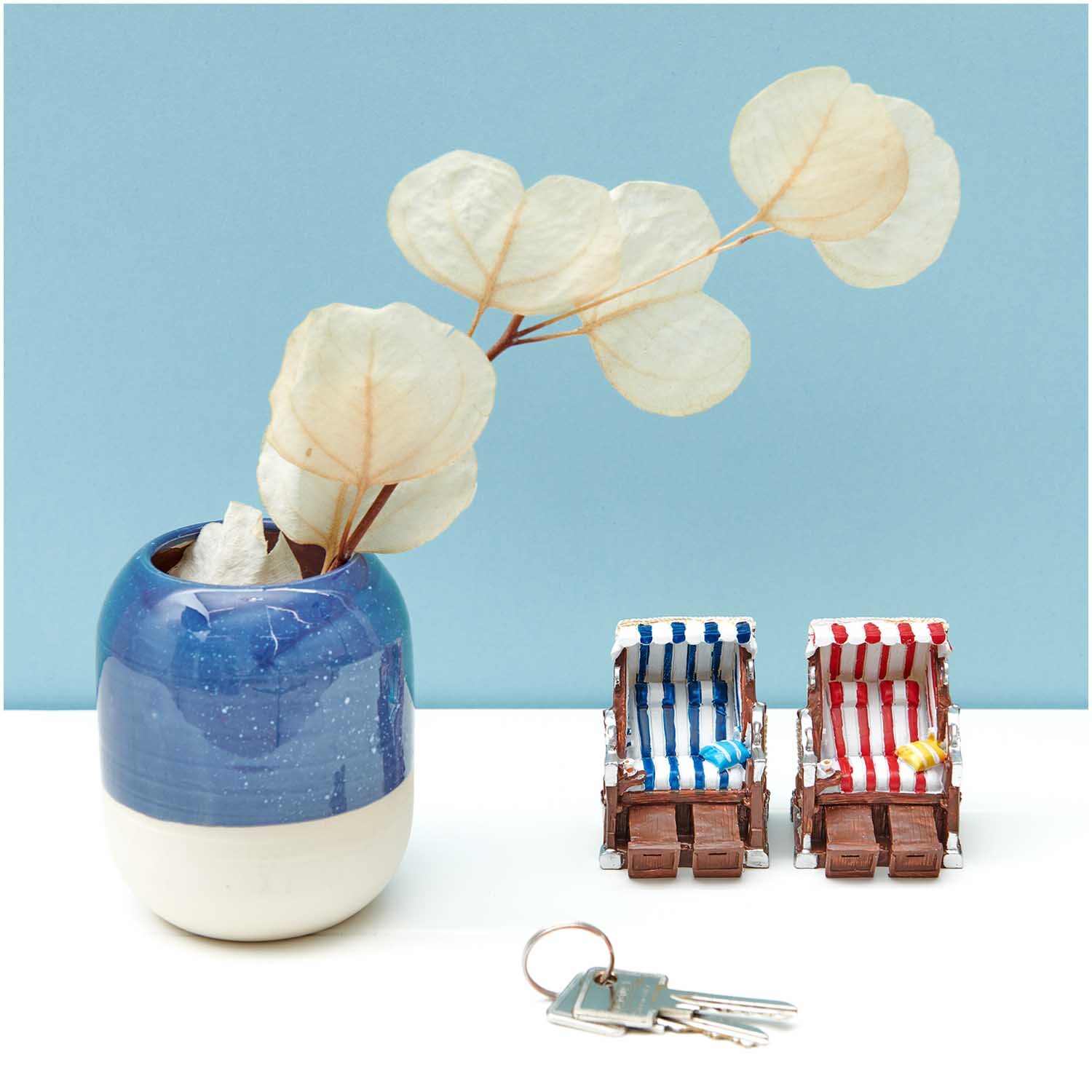 Deko-Strandkorb rot-weiß 5x6,5cm von Rico Design neben blauem Keramiktopf mit Trockenblumen.
