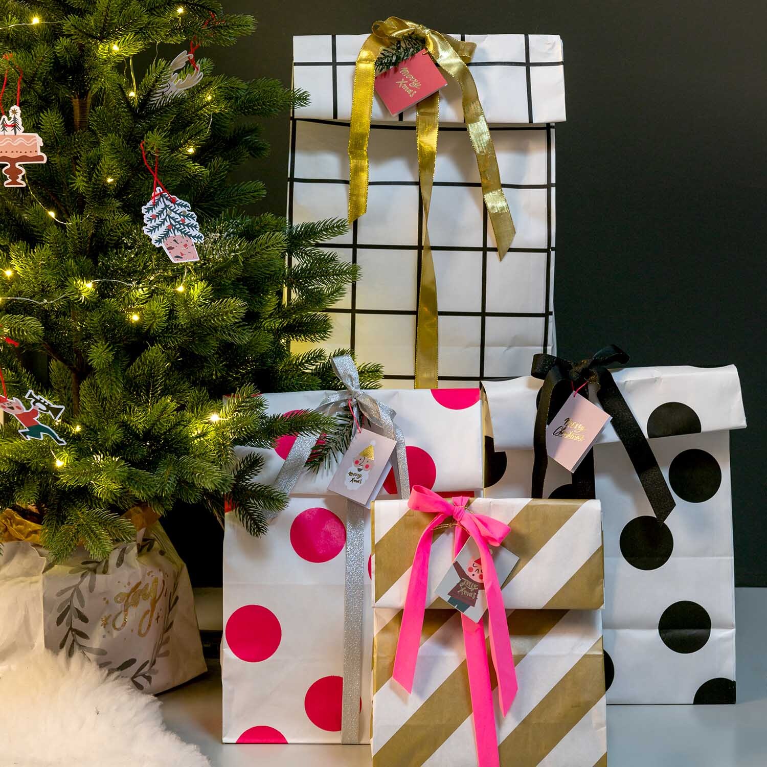 Paper Poetry Papieranhänger Jolly Christmas Classic 8 Stück an Geschenken unter einem festlich geschmückten Weihnachtsbaum.