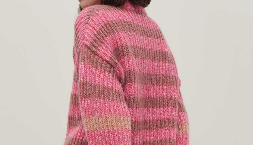 Strickanleitung Pullover aus Fashion Fabulous 4 aran: Frau trägt gestreiften Pullover in Rosa- und Brauntönen.