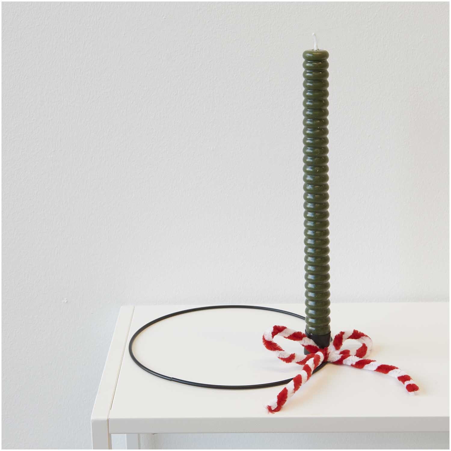 Chenilledraht-Mix 50cm 10 Stück rot & weiß von Rico Design, dekorativ um eine grüne Kerze gewickelt auf einem Tisch.