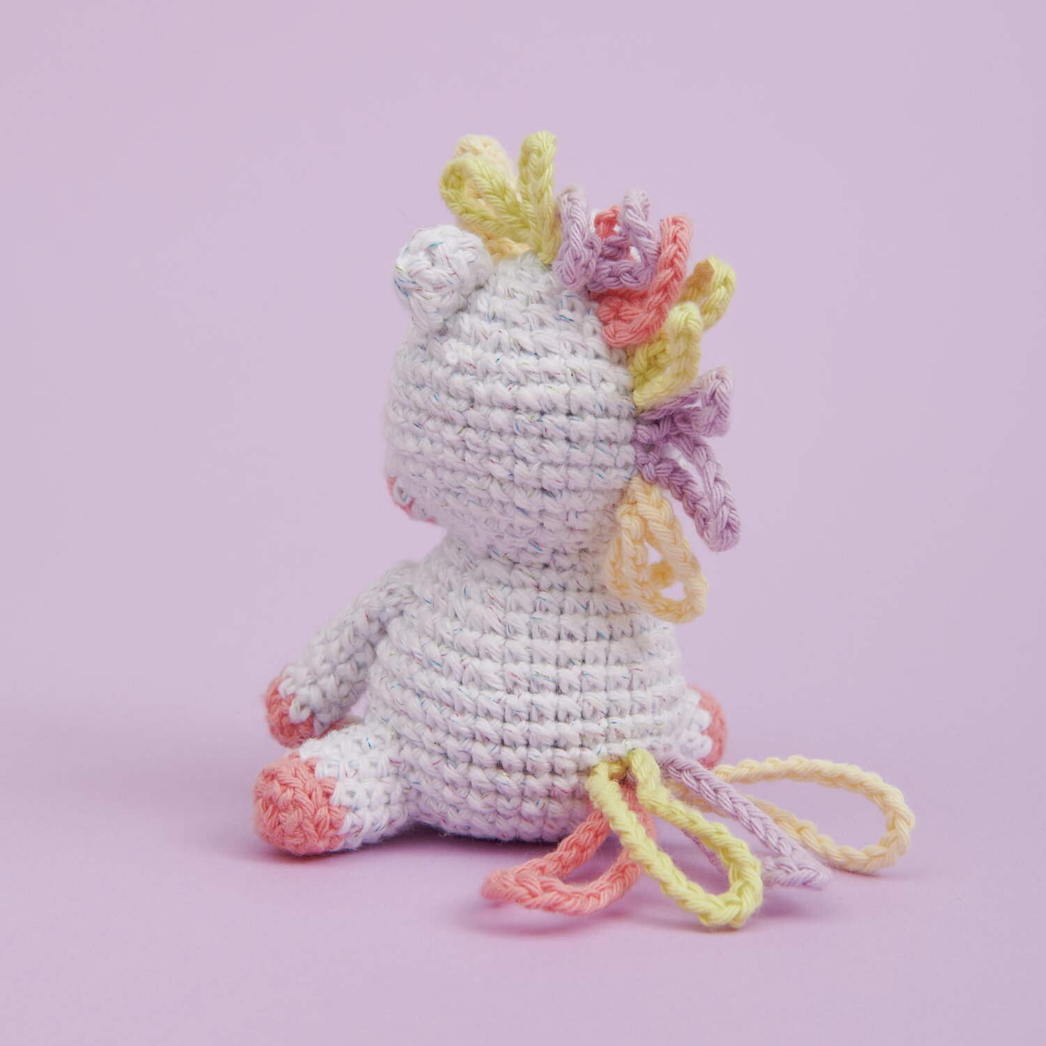 Ricorumi Mini Easy Häkelset - Einhorn: Pastellfarbenes gehäkeltes Einhorn von Rico Design auf lila Hintergrund.