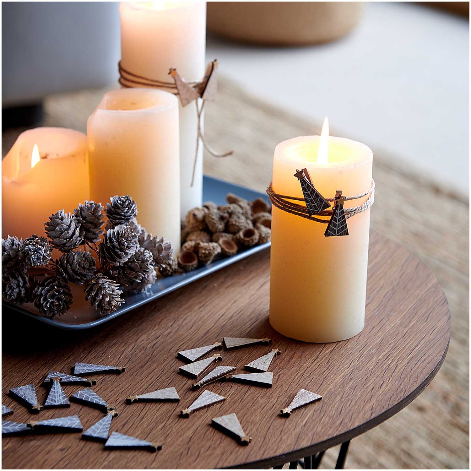 Holzstreu Tannenbaum shabby chic dekoriert einen Tisch mit brennenden Kerzen und Tannenzapfen.