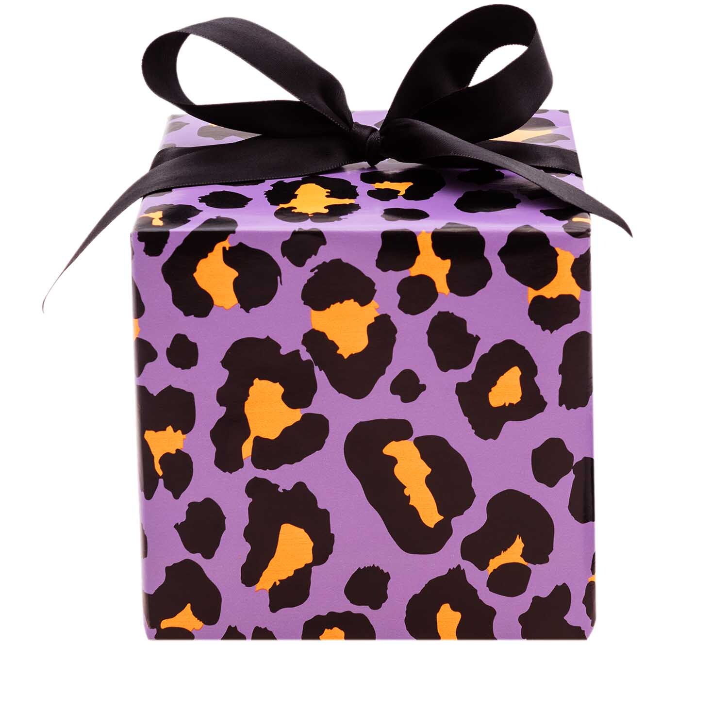 Paper Poetry Geschenkpapier mit Leopardenmuster in Flieder, verpackt als Geschenk mit schwarzer Schleife. Ideal für stilvolle Präsentationen.