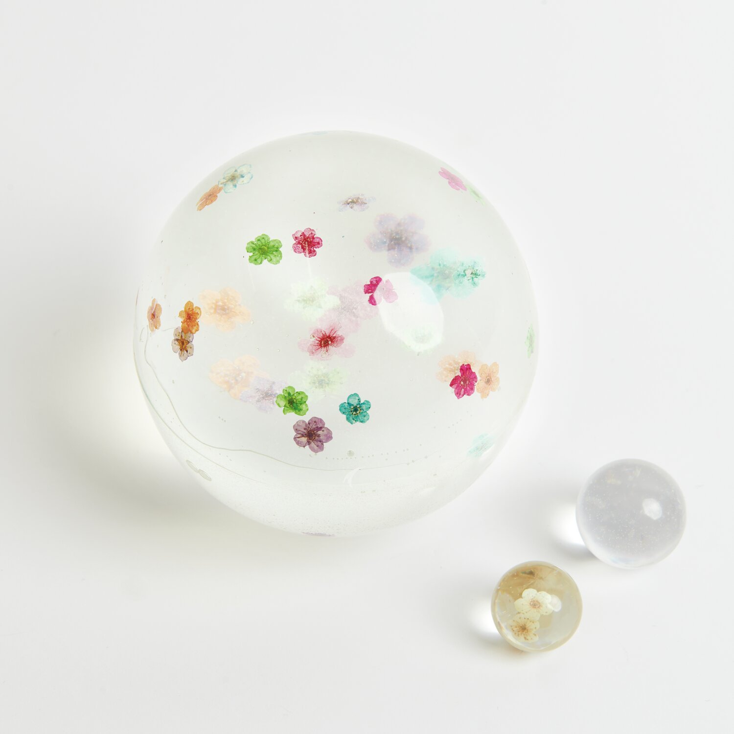 Epoxidharz transparent: Kugel mit bunten Trockenblumen, ideal als Füllmaterial für kreative Projekte.