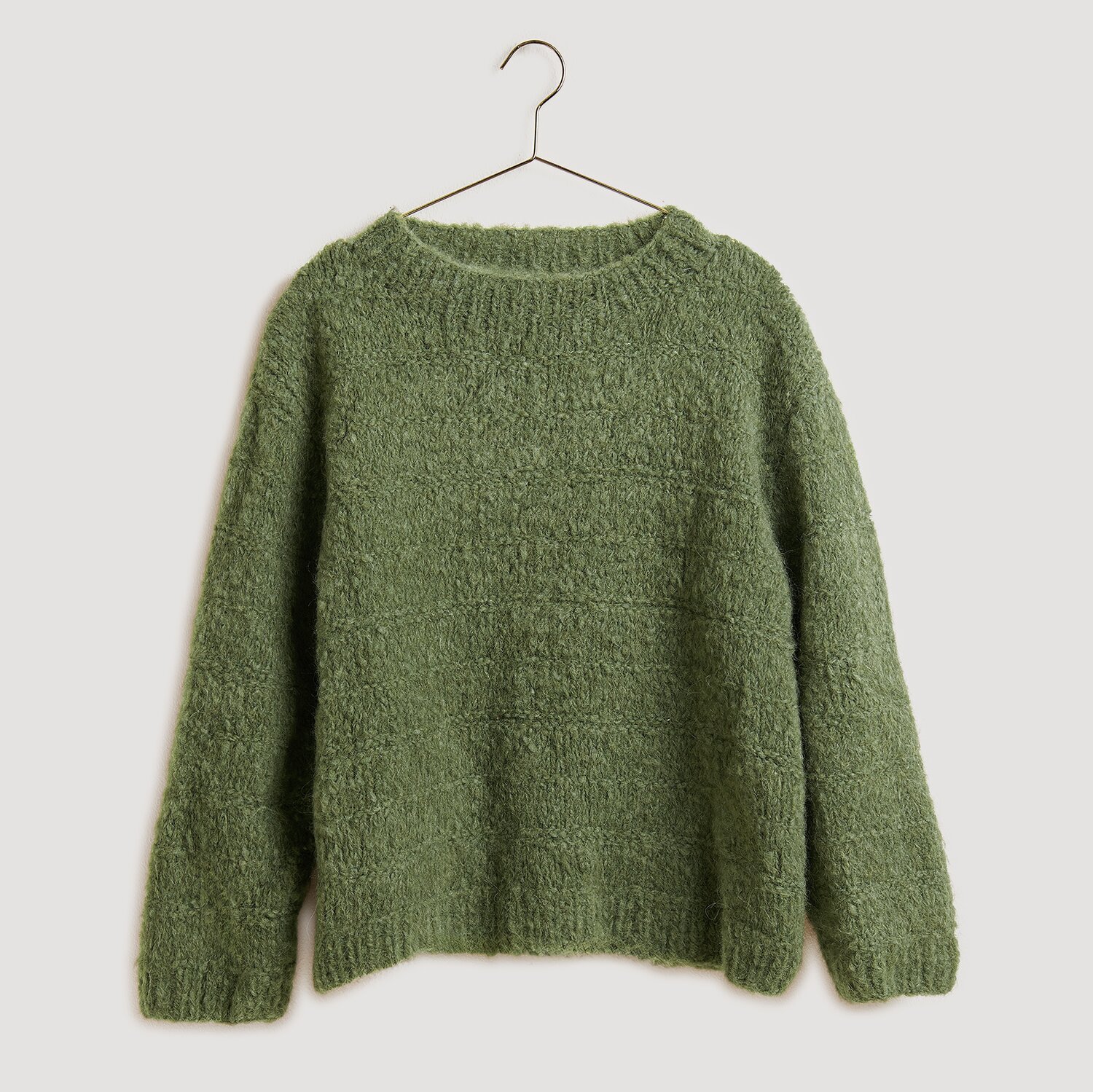 Gestrickter Pullover in Grün auf Bügel
