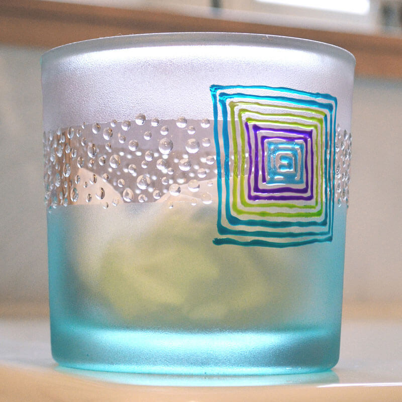 Satiné matt Glas 82ml mit buntem geometrischem Muster und Perlenstruktur, türkisfarben.