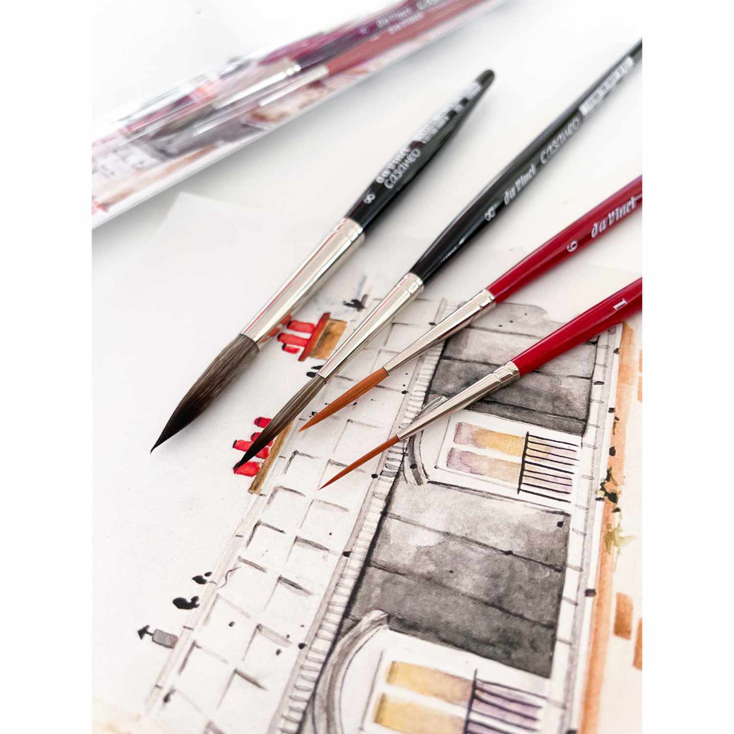 da Vinci Pinsel-Set Urban Watercolor Schlepper Crew: Vier Pinsel auf einem Aquarellbild, ideal für präzise Details. Marke: May&Berry.