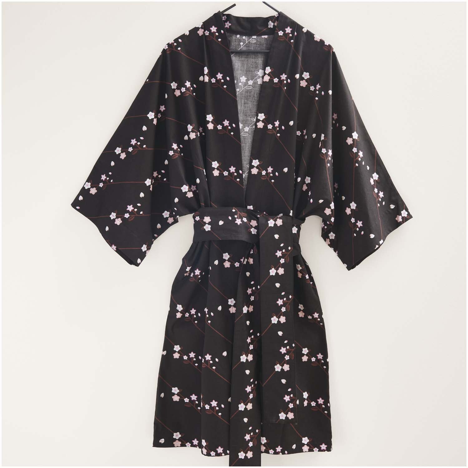 Meterware Baumwoll-Popelin schwarz Sakura Zweige zeigt einen Kimono mit zarten Blütenmustern. Ideal für stilvolle Nähprojekte.