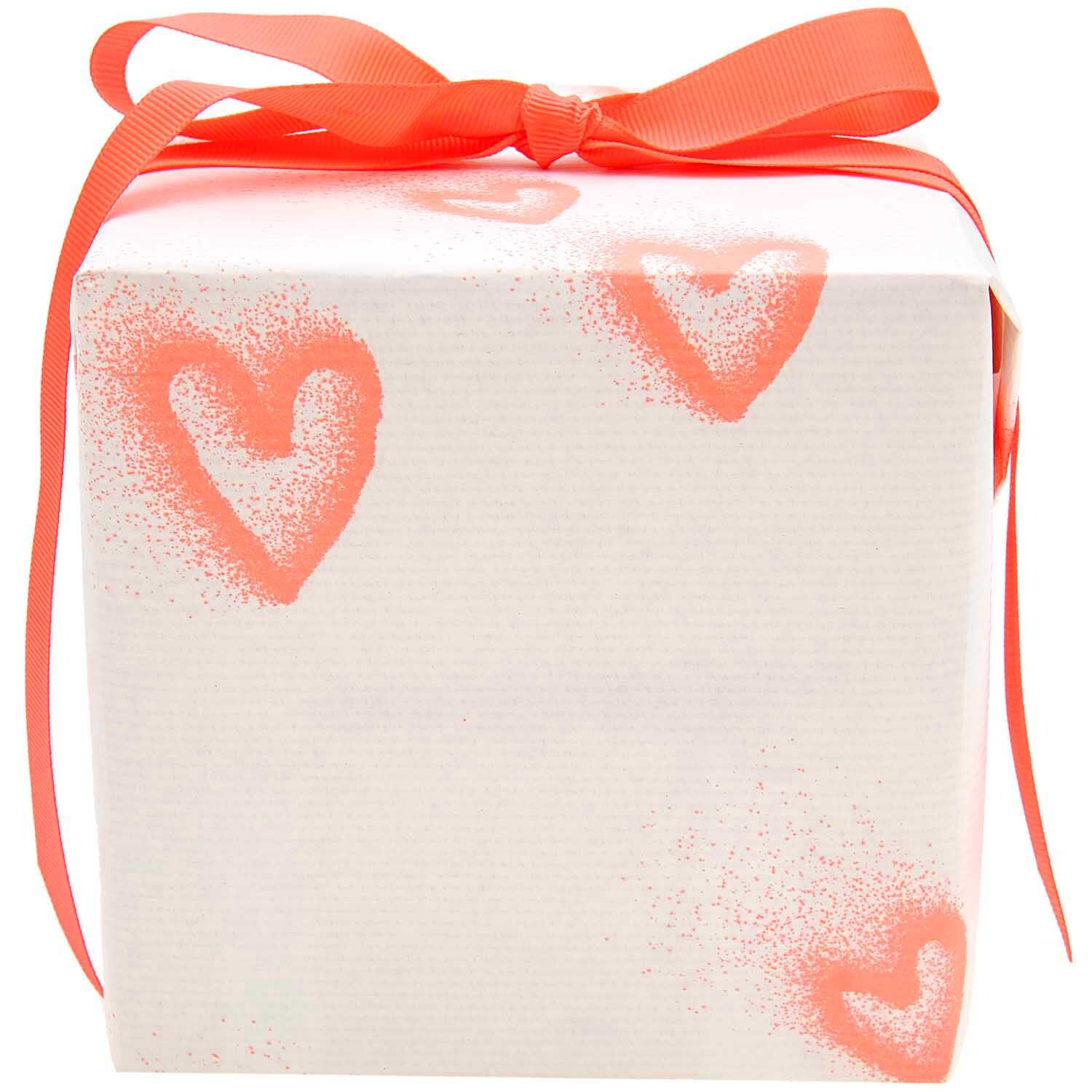 Paper Poetry Geschenkpapier mit neonroten Sprayherzen, verpackt als Geschenk mit rotem Band. Ideal für kreative Verpackungen.