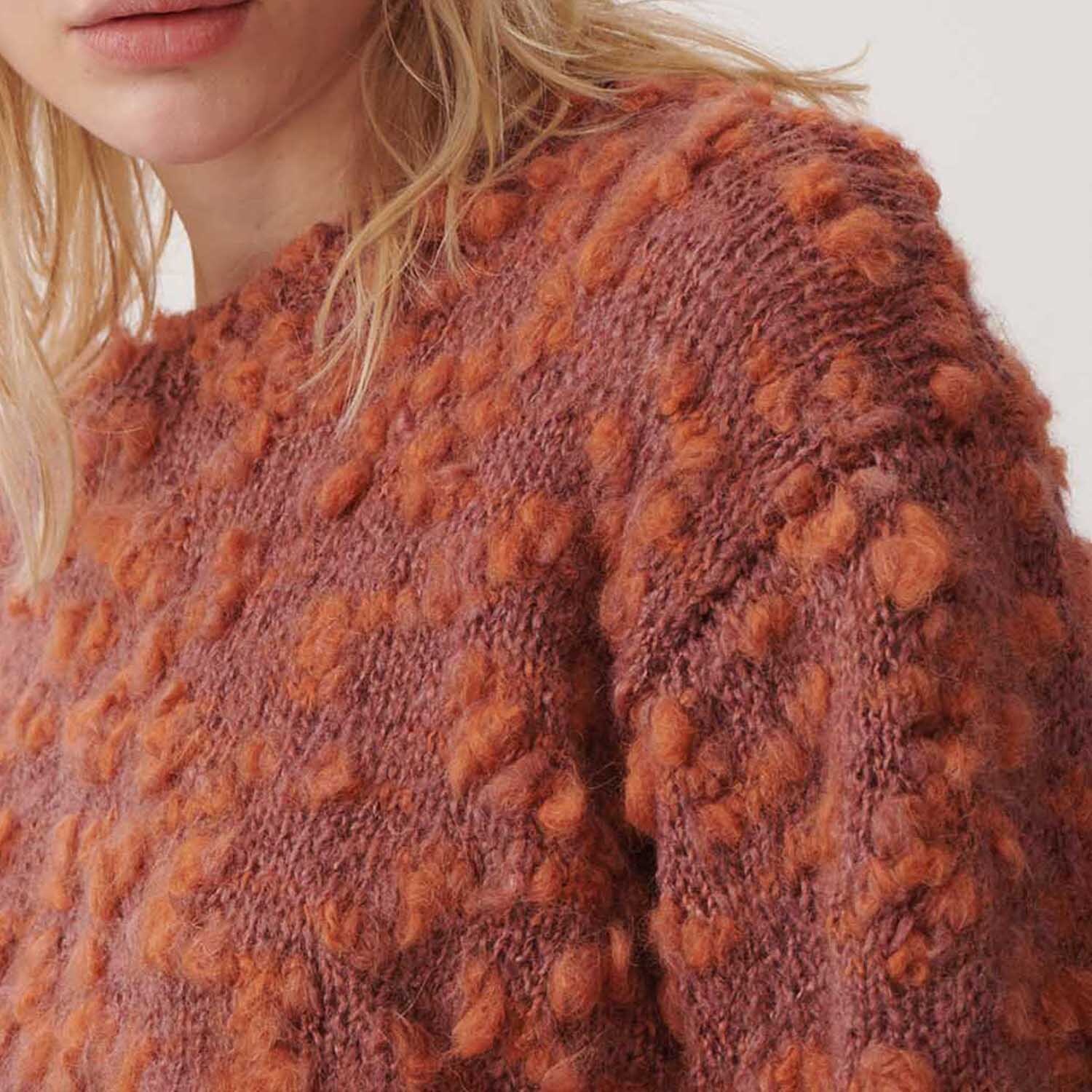 Fashion Alpaca Vibes aran: Nahaufnahme eines gestrickten Pullovers in Lila-Orange von Rico Design.
