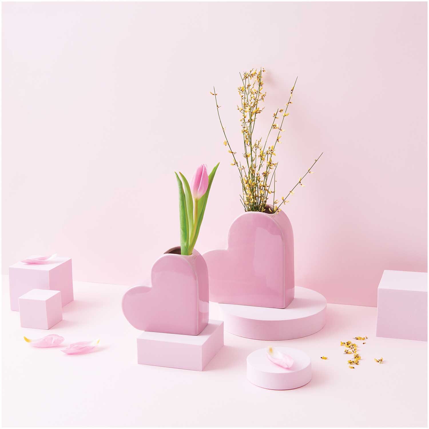 Keramik Vase Herz klein 12x5,5x12cm mit Tulpe und Zweigen, dekorativ arrangiert auf rosa Hintergrund.