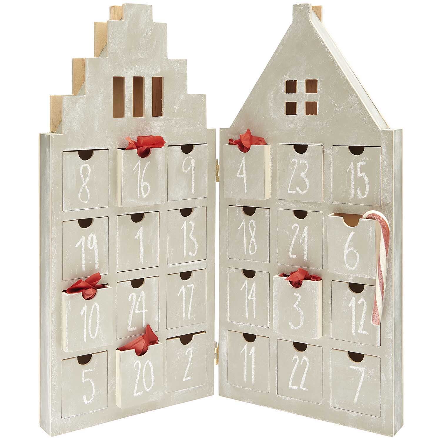 Adventskalender Haus aus Holz mit 24 nummerierten Schubladen, verziert mit roten Schleifen. Ideal für festliche Dekorationen.