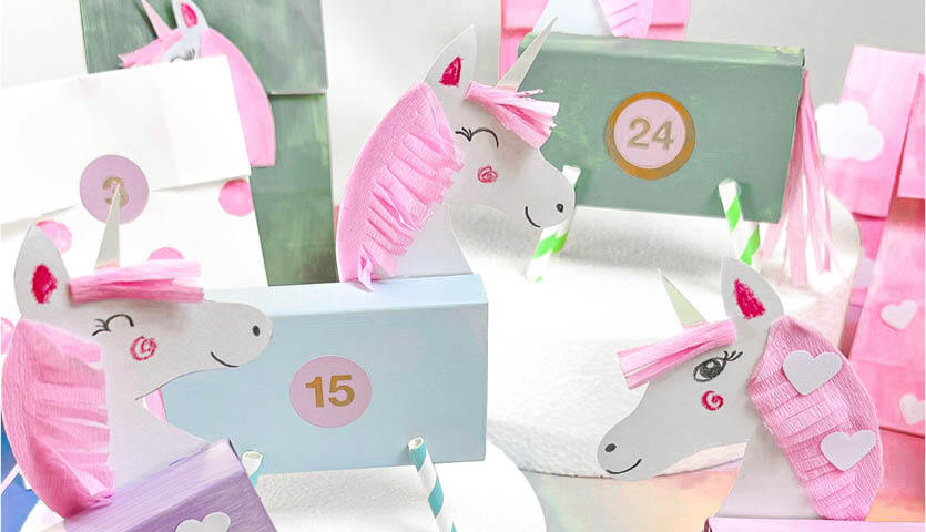 Bastelanleitung Adventskalender: Einhörner aus Papier in Pastellfarben mit Nummern und Herzen.