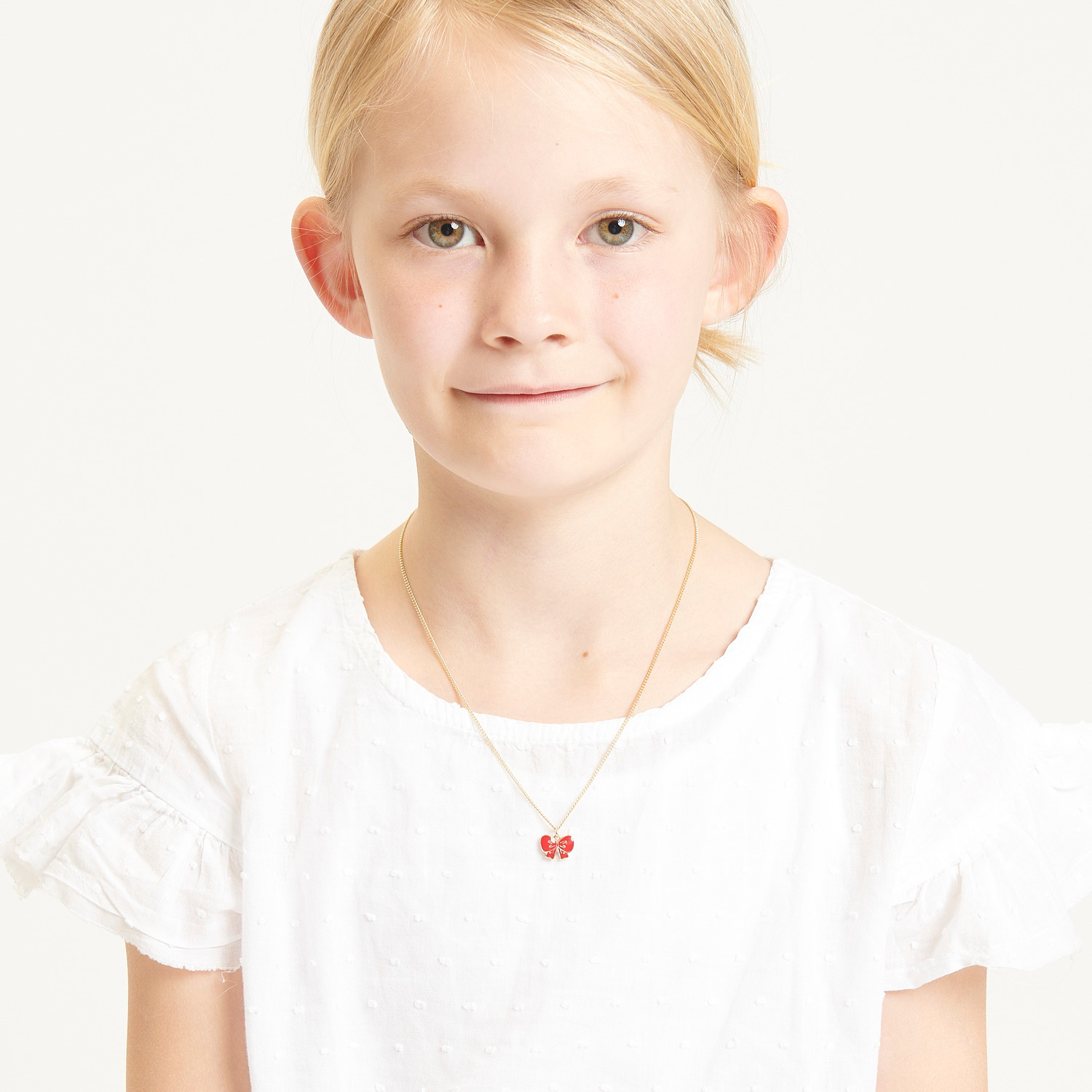 Kette mit Anhänger Schleife, 40cm, von Rico Design. Mädchen trägt eine weiße Bluse.