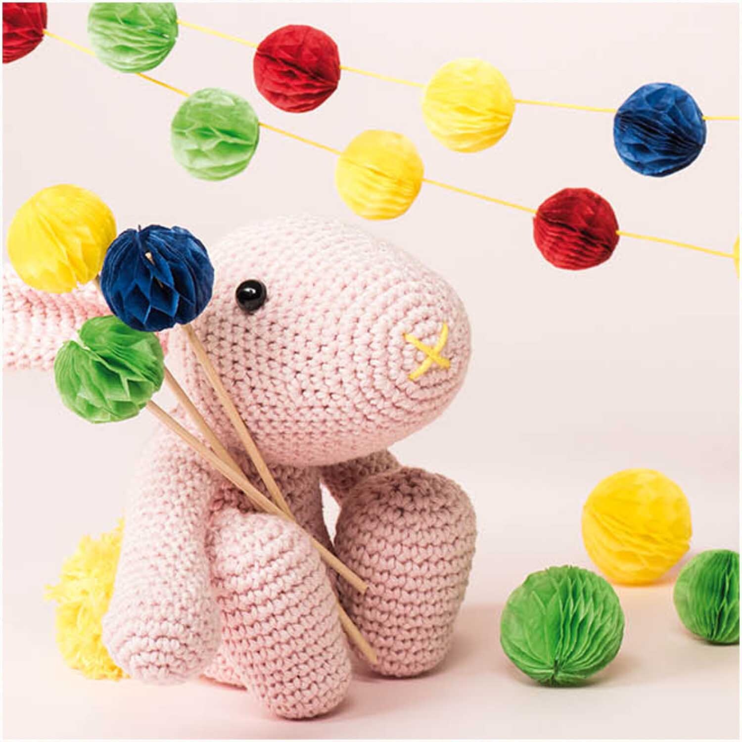 Wabenpapier mehrfarbig Mix 20x33cm 4 Bogen: Ein gehäkelter Hase hält bunte Papierkugeln, umgeben von farbenfrohen Girlanden.