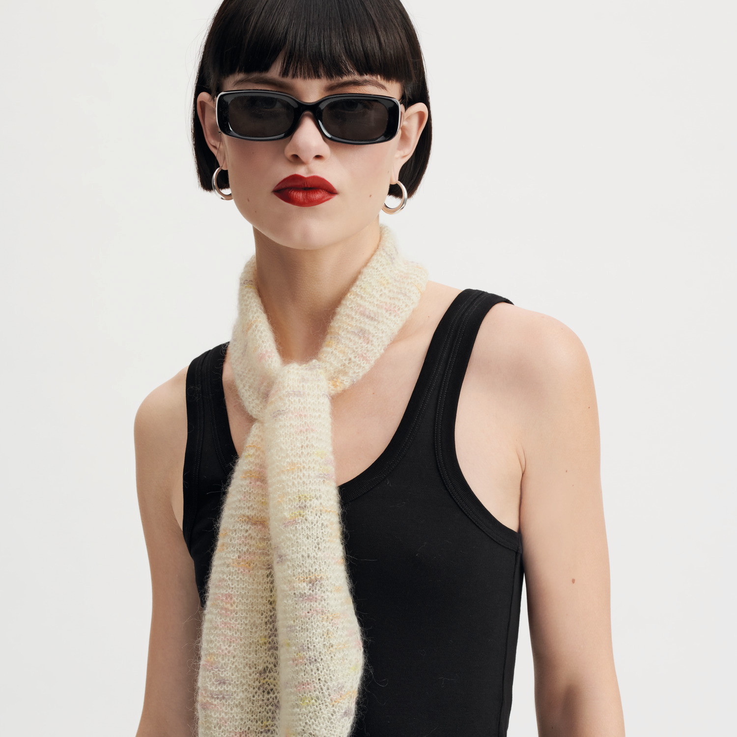Strickset Tuch Modell 16 aus Made by Me Nr. 18: Frau mit hellem Strickschal, schwarzem Top und Sonnenbrille.