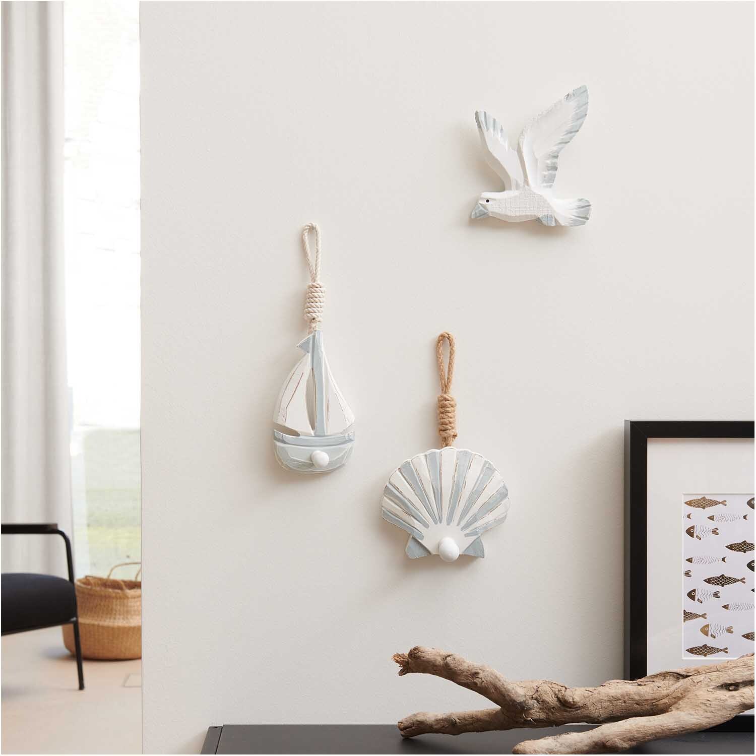 Aufhänger Muschel grau-weiß 11,5x14,5cm, Segelboot 16x9cm und Möwe 15x13cm an weißer Wand.