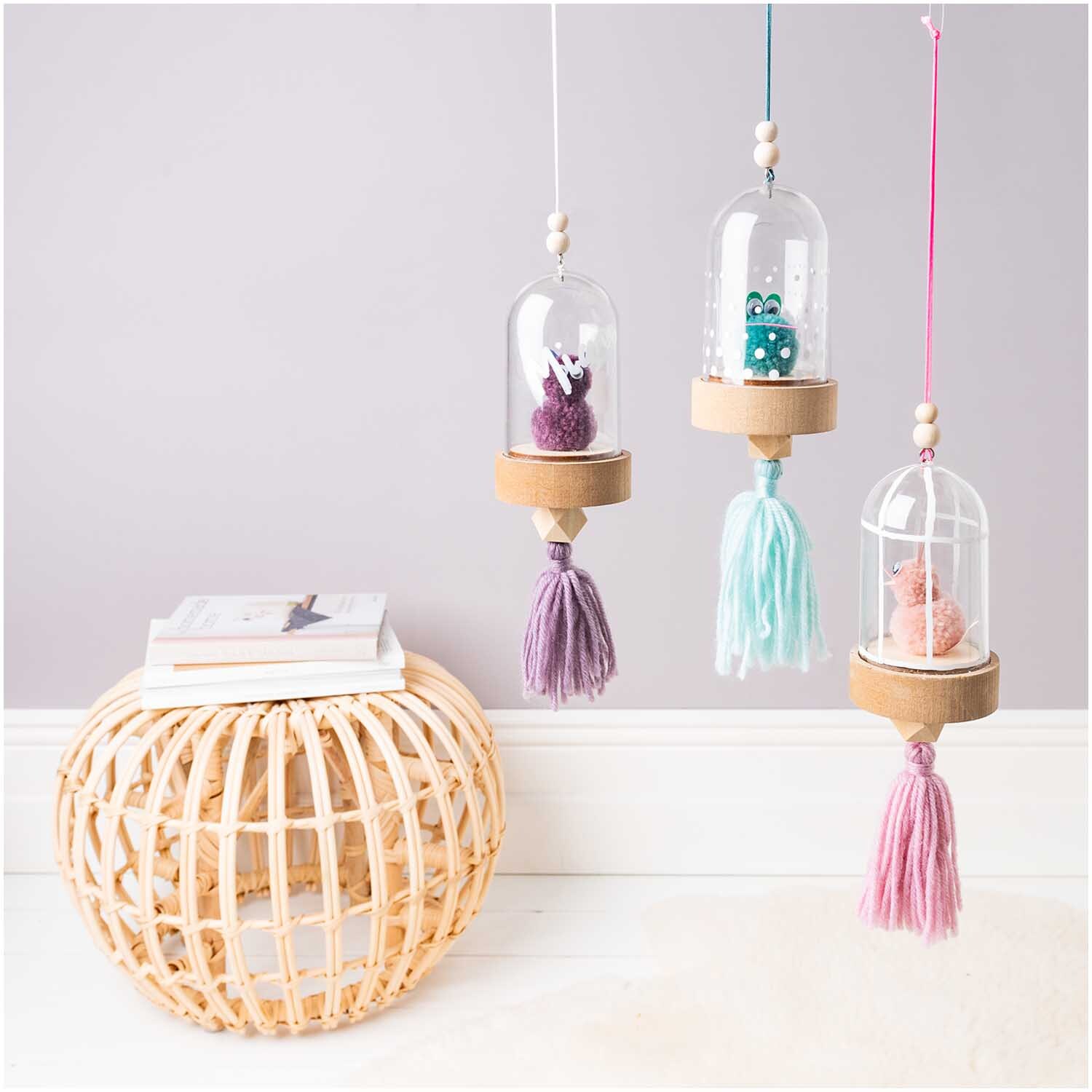 Quasten 9cm 4 Stück: Dekorative Quasten in Glaskuppeln, hängend in Pastellfarben, von Rico Design.