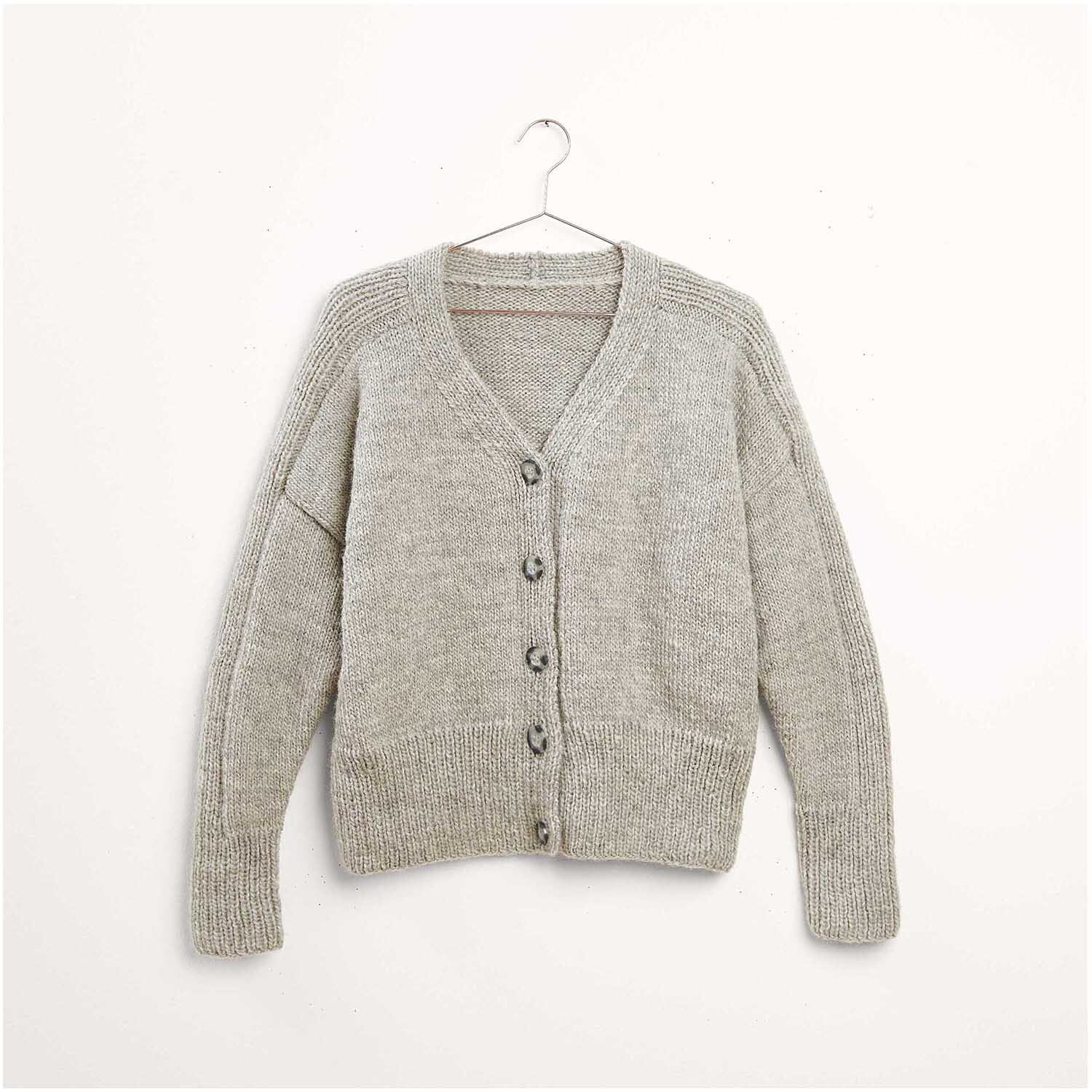 Strickset Jacke Modell 08 aus Luxury Knits Winter Special, graue Strickjacke mit Knopfleiste, hängend an einem Kleiderbügel vor weißem Hintergrund.