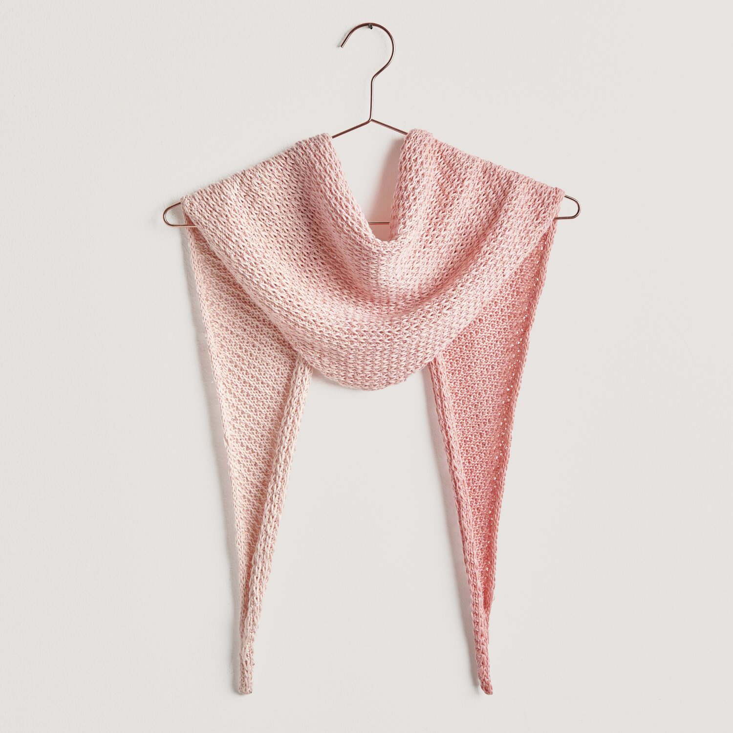 Strickset Dreieckstuch Modell 10c aus Lovewool No. 20, in Apricot und Rosa, auf einem Kleiderbügel.