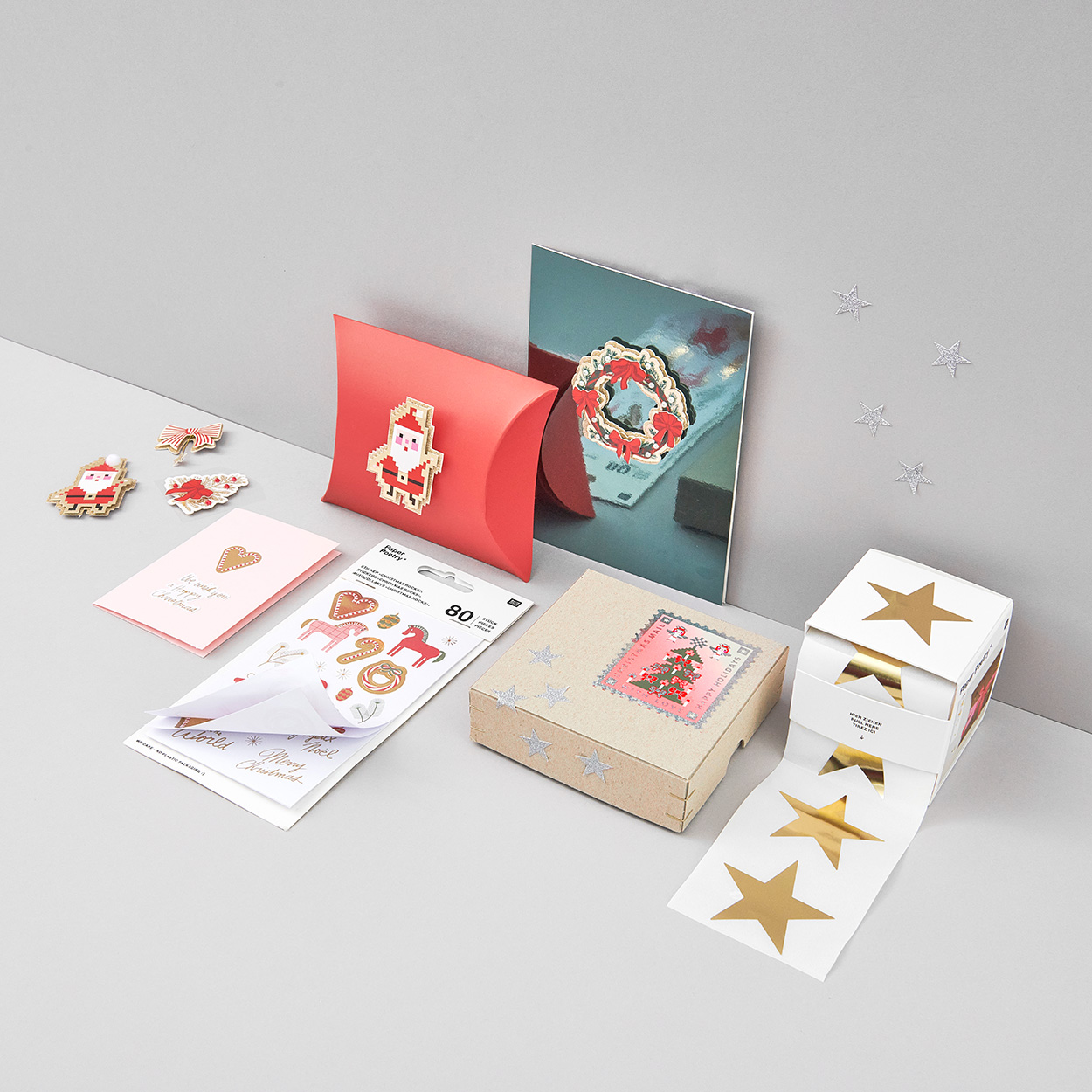 Verschiedene weihnachtliche Sticker und Papierschachteln. Fotosetting graue Ecke.